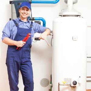 A plumber from Kent is standing beside a water tank, assessing the plumbing issue. The tank seems to be leaking, and the plumber is examining the situation to determine the cause of the leak. The plumber is prepared to fix the issue and ensure the proper functioning of the water tank.
