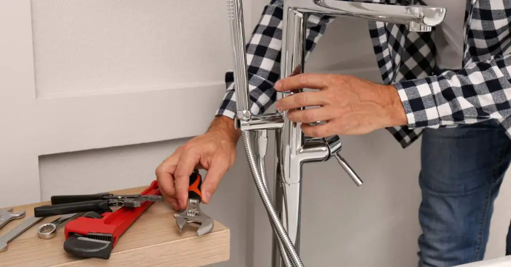 A skilled engineer from Ashford Plumbing is diligently fixing a tap.